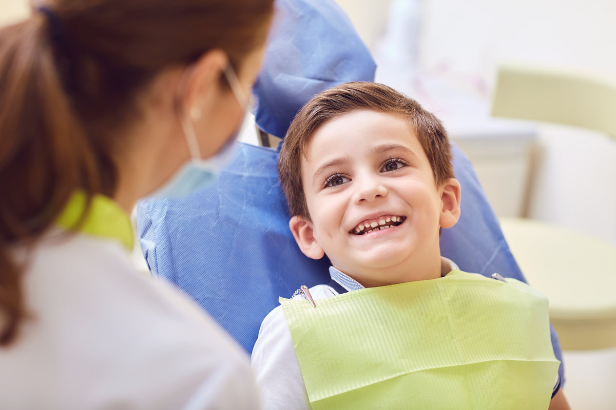 A child with a dentist in a dental office. Dental treatment in a children's clinic.