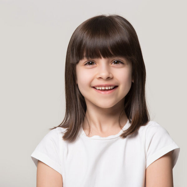 Close up headshot portrait of smiling little girl isolated on grey studio background look at camera, happy small preschooler child in white t-shirt posing feel overjoyed excited show healthy teeth