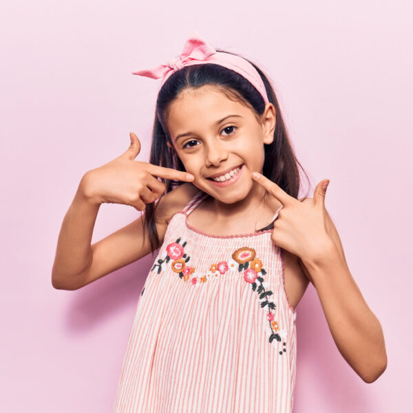 Beautiful child girl wearing casual clothes smiling cheerful showing and pointing with fingers teeth and mouth. dental health concept.