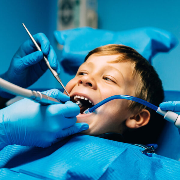 Dentists with a patient during a dental intervention to boy. Dentist Concept