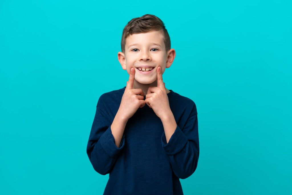 Little kid boy isolated on blue background smiling with a happy and pleasant expression