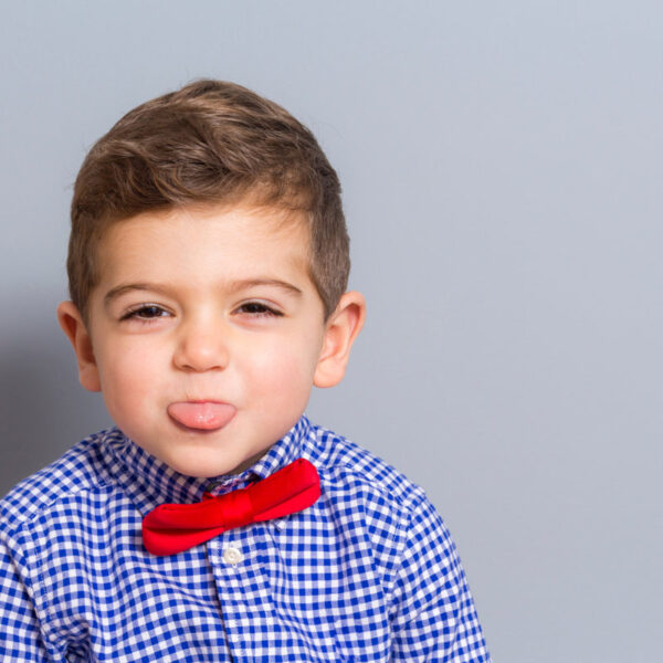 Cute boy with bow tie making a grin
