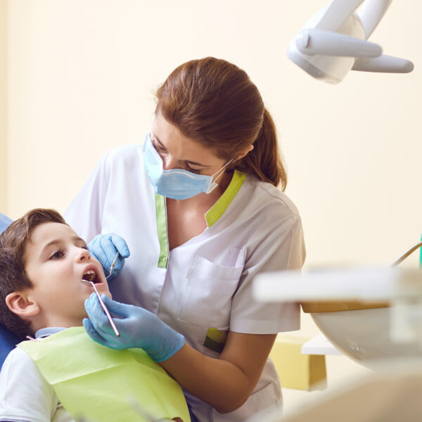 A child with a dentist in a dental office. Dental treatment in a children's clinic.