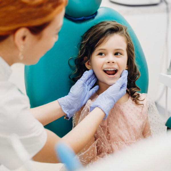 Portrait of a lovely little kid showing teeth to the pediatric dentist.