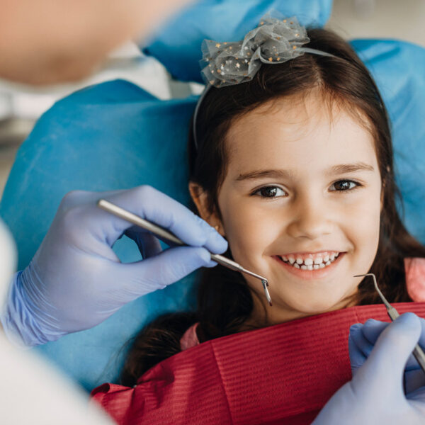Close up of a happy little girl looking at camera before teeth examination in a pediatric stomatology.