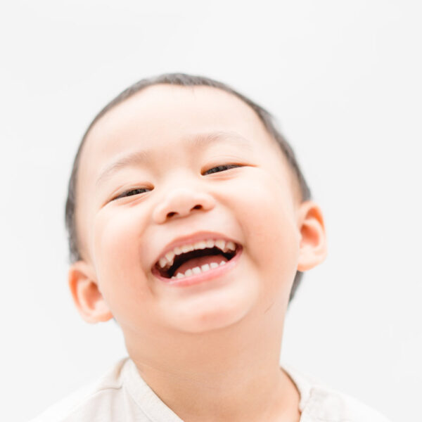 Happy Little asian boy child showing front teeth with big smile and laughing: Healthy happy funny smiling face young adorable lovely toddler kid.Joyful portrait of asian kindergarten school student.