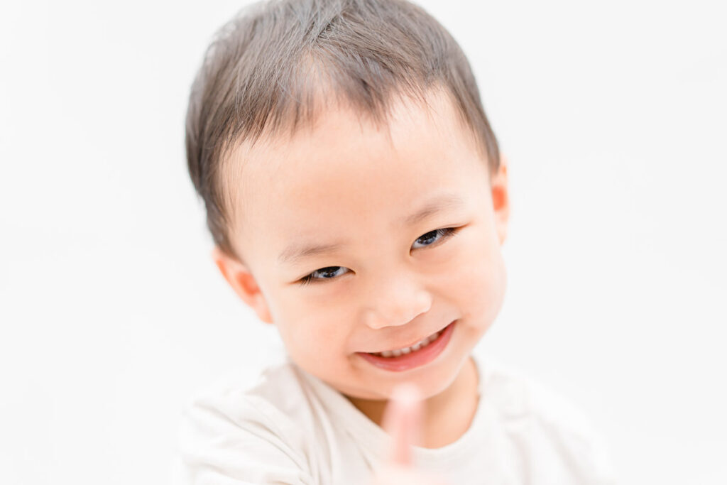 Happy Little asian boy child showing front teeth with big smile and laughing: Healthy happy funny smiling face young adorable lovely toddler kid.Joyful portrait of asian kindergarten school student.