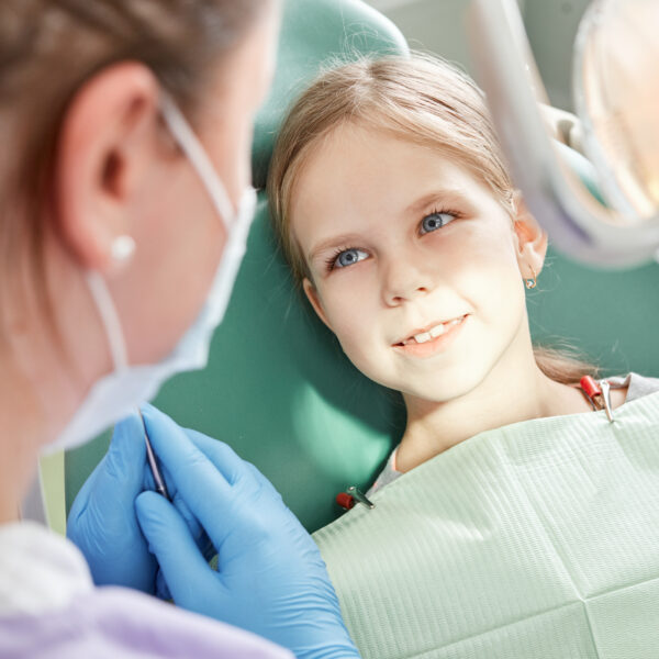 Child to the dentist. Child in the dental chair dental treatment during surgery. Small patient visiting specialist in dental clinic.