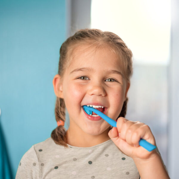little girl brushing teeth in the bathroom