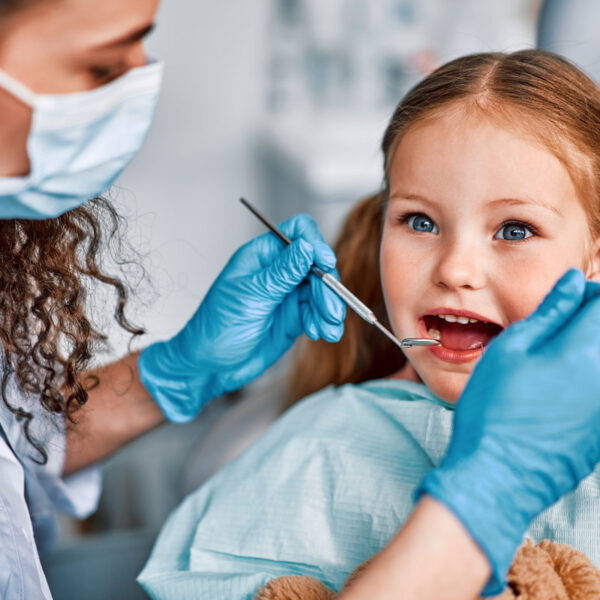 At the doctor's appointment. Portrait of a child being examined by a dentist.