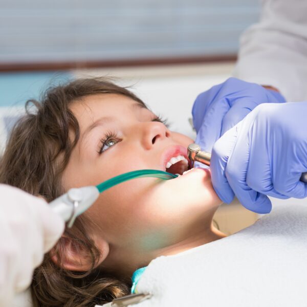 Pediatric dentist examining a boys teeth