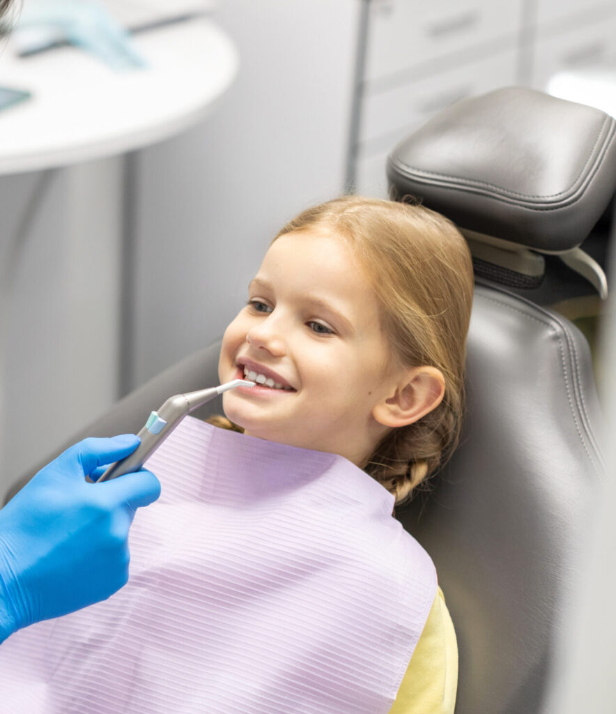 Professional hygiene for child teeth. Male dentist exaamining and consulting kid girl patient in dentistry clinic office