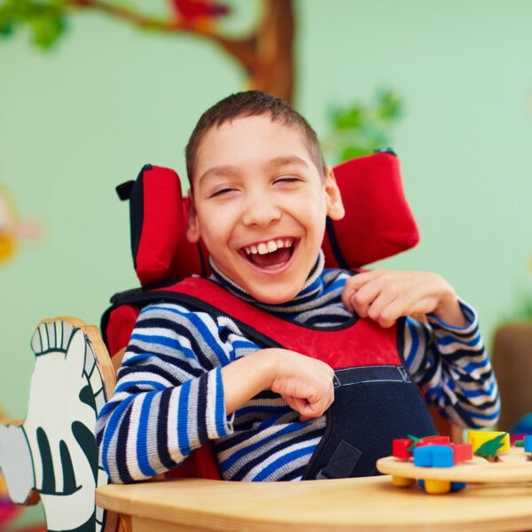 cheerful boy with disability at rehabilitation center for kids with special needs