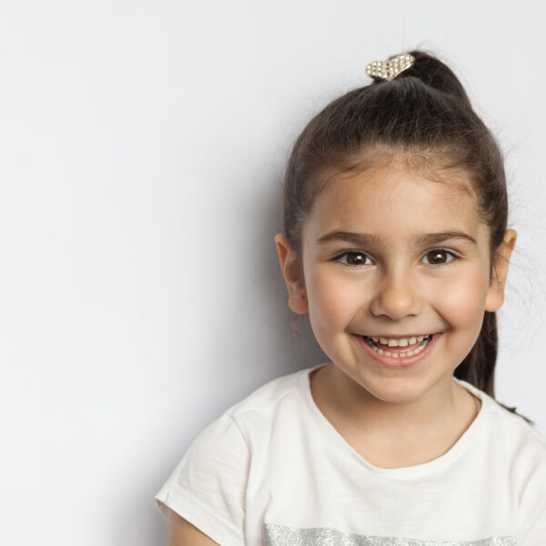 Portrait of happy cute brunette child girl on white background