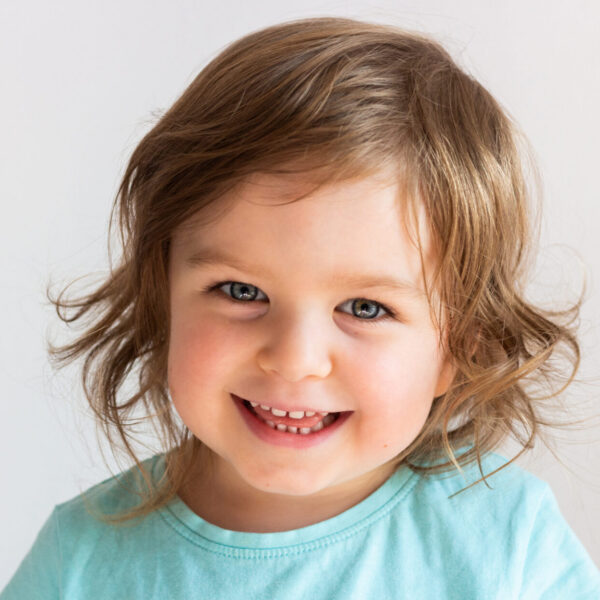 Beautiful happy toddler child girl smiling, portrait neutral background, space for text