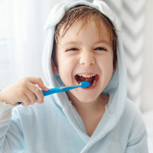 Morning routine, smiling happy child brushing teeth with toothbrush. Dental hygiene of little boy, medical care.