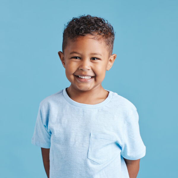 Happy, portrait and a child with a smile for dental care isolated on a blue background in a studio. Smile, kindergarten and a little boy kid smiling with happiness about young oral hygiene results.