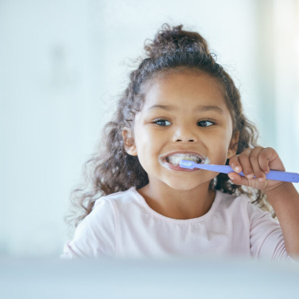 Girl, brushing teeth and smile for hygiene, clean mouth and fresh breath for oral care and dental health. Child, cleaning and toothpaste with toothbrush, bathroom and wellness in family home.